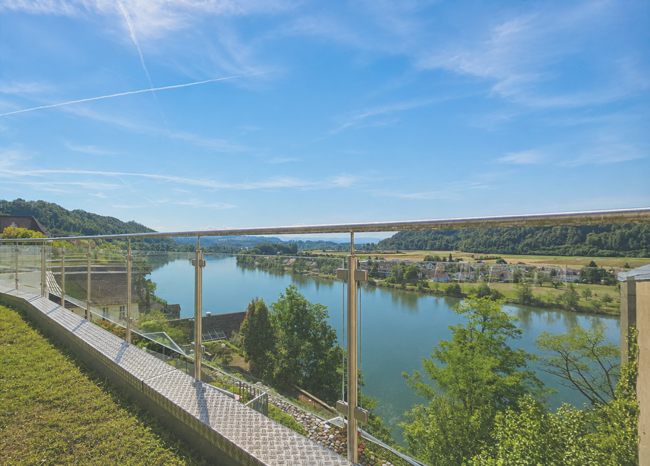 Panoramablick auf Fluss, Brücke und grüne Landschaft bei Schlatter Immobilien.