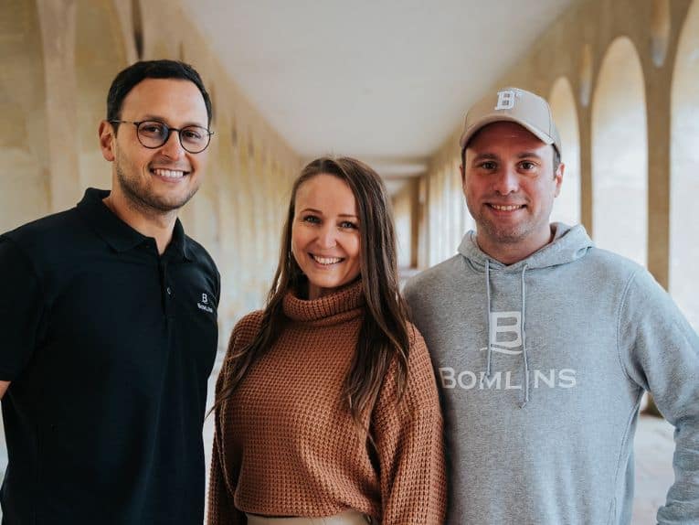 Drei Personen in einem Flur.