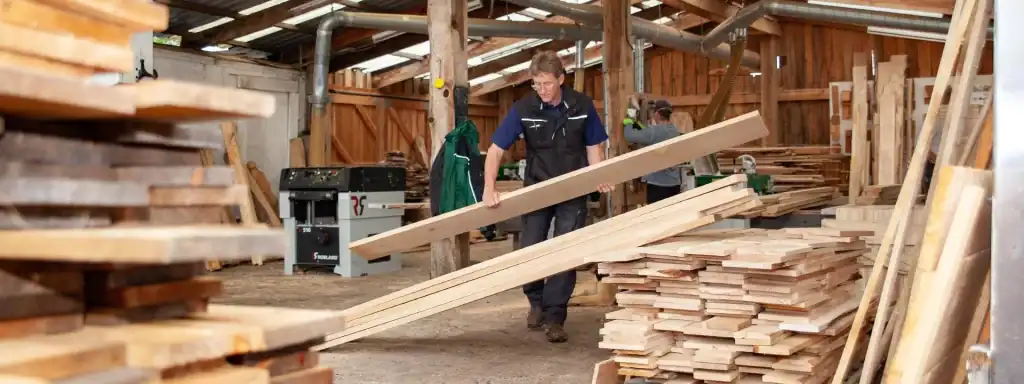 Jim Birley carrying a wood plank in the Scottish Wood samwill