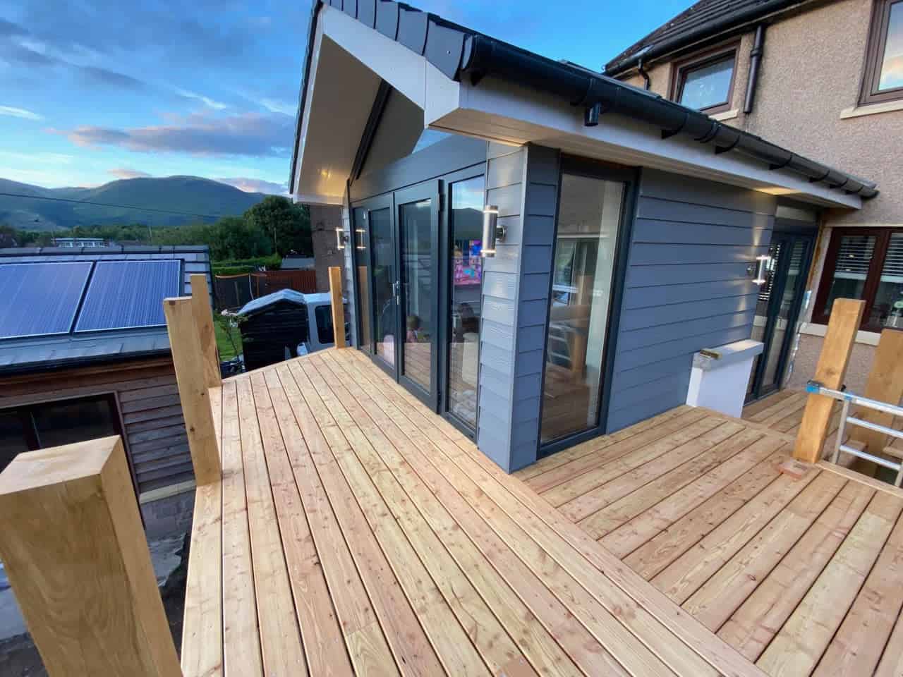 New larch decking being installed on house garden by Neil Porteus Building