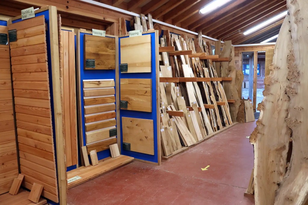 View of a timber shop full of hardwood boards with live edges and a display area for cladding