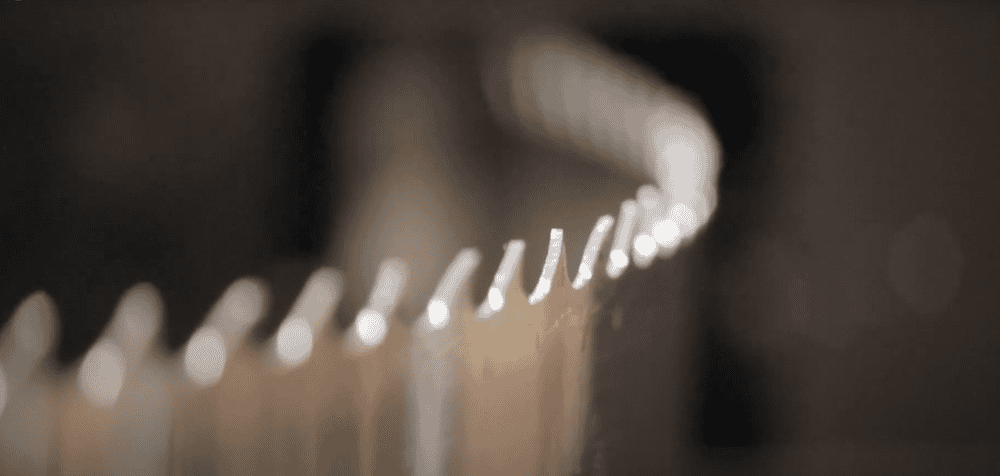 Close up of bandsaw blade being fed trough sharpener - a still shot from the bandsaw blade maintenance video