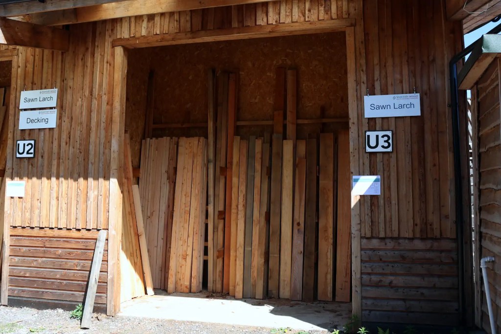 View of larch timber bays outside the Scottish Wood shop, selling Scottish larch boards, posts, decking, and cladding