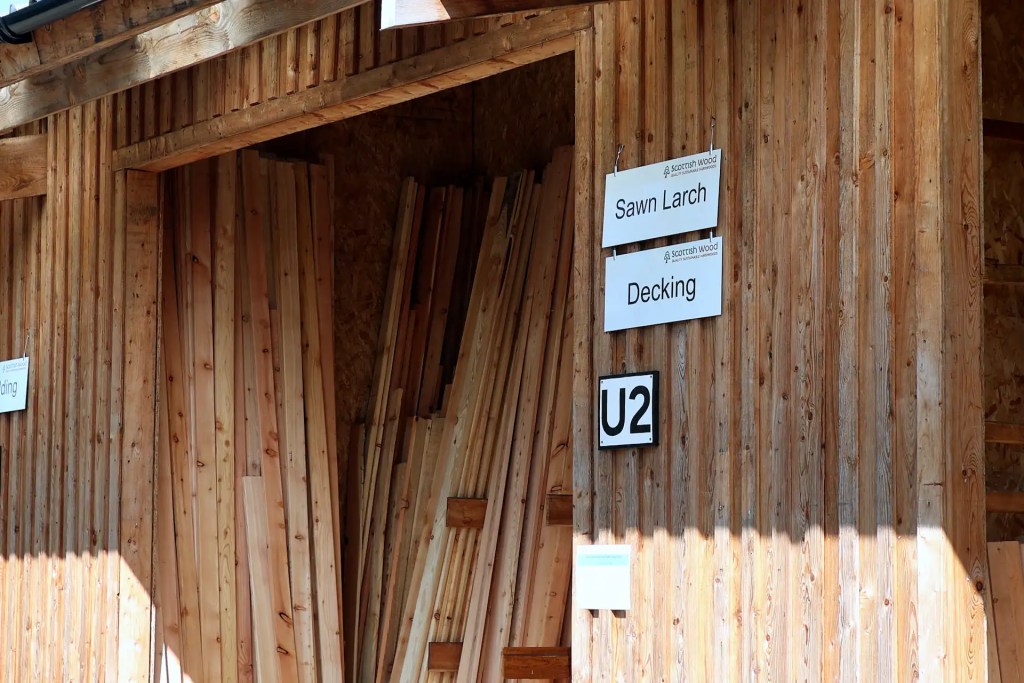 View of larch timber bays outside the Scottish Wood shop, selling Scottish larch boards, posts, decking, and cladding
