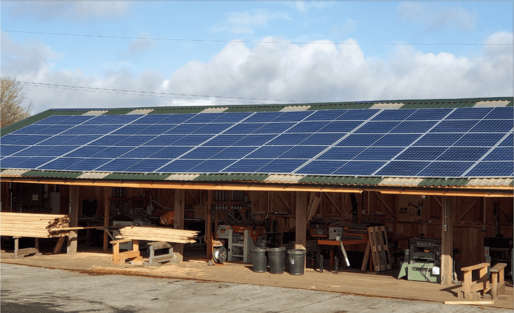 Solar panels mounted on a large open faced timber machinery shed at Scottish Wood - south facing