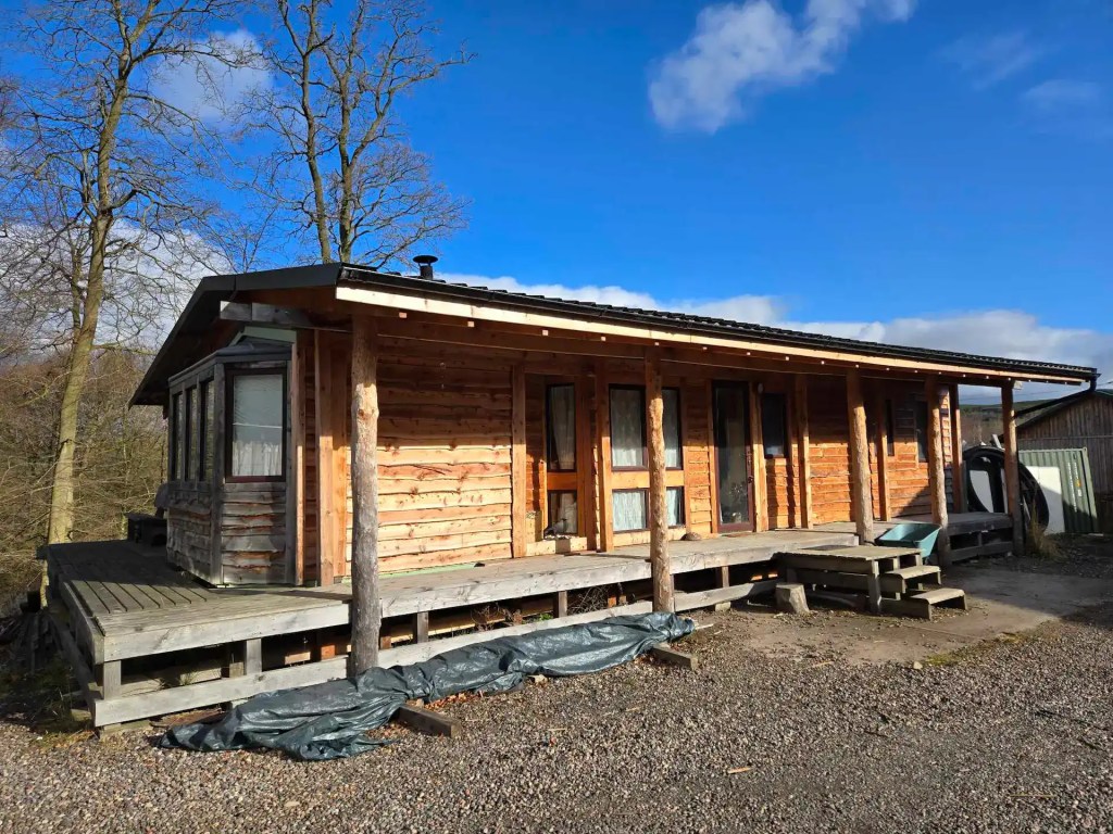 Static caravan clad with waney edge cladding - transforming it into a rustic timber cabin