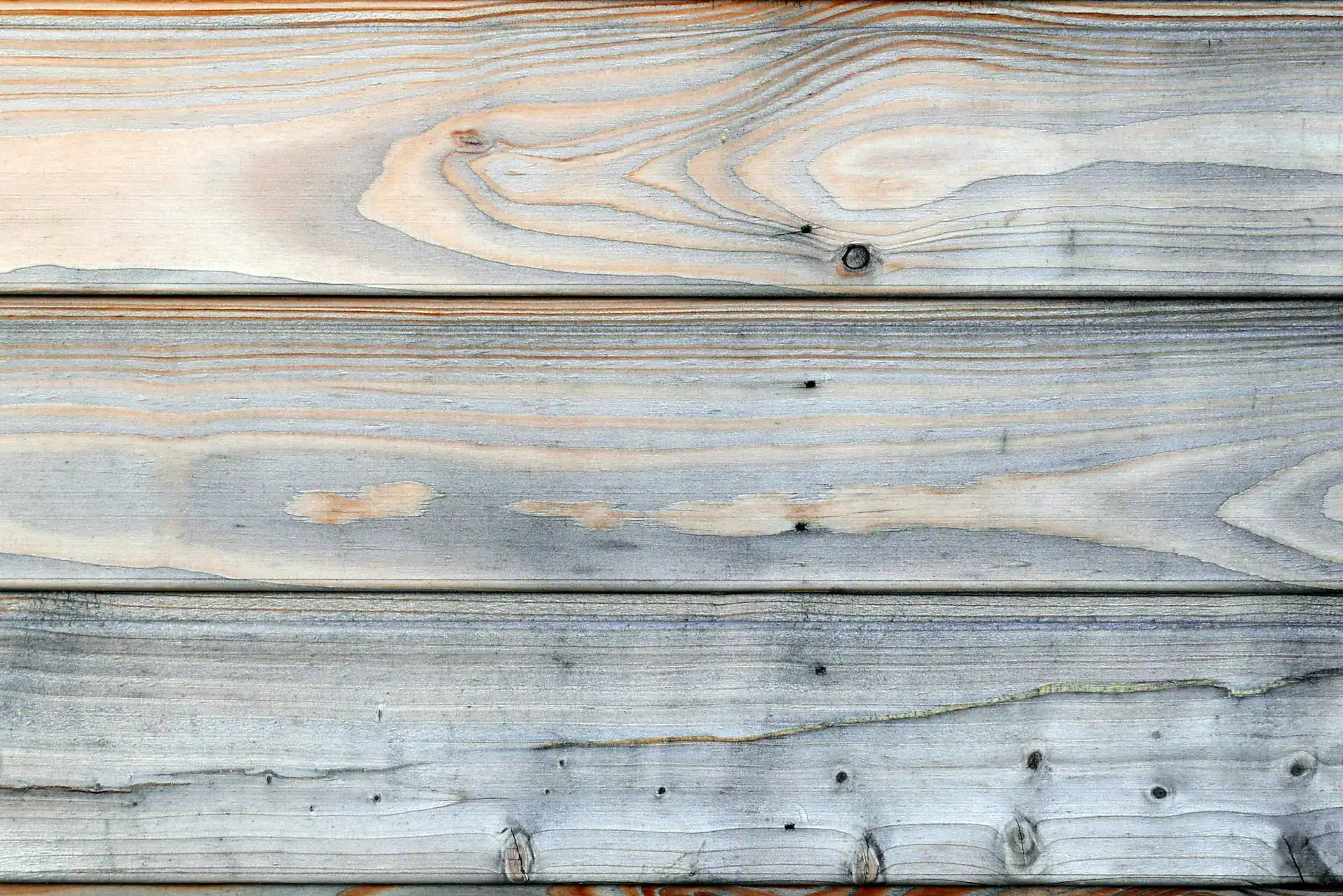 Larch cladding that is somewhat weathered with patchy silver areas
