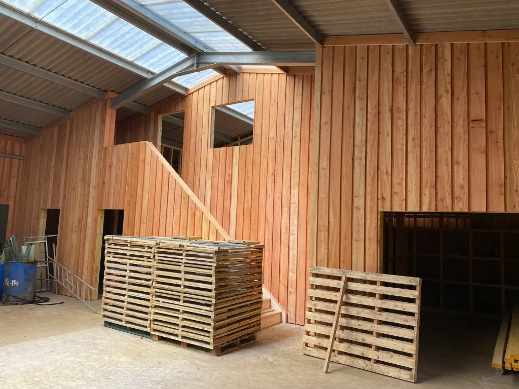 Interior of farm building with board on board larch cladding which has preserved its natural color