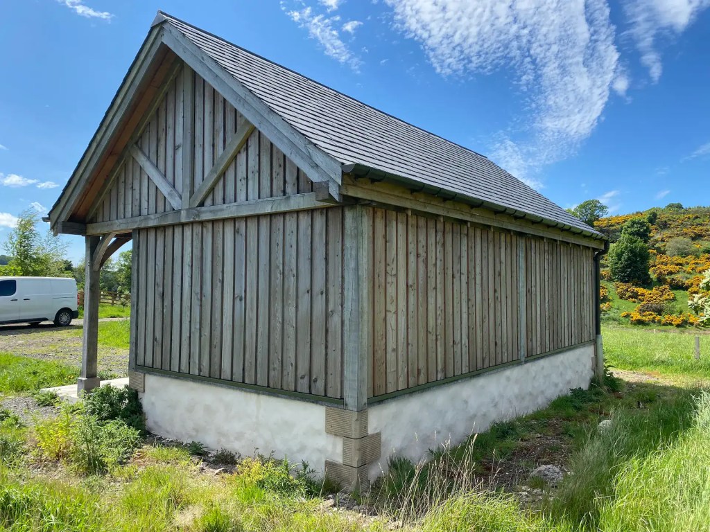 Board on board clad post and beam shed, the larch cladding has weathered to an even silver-grey