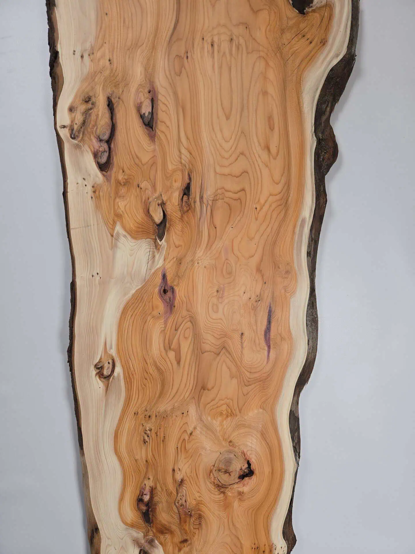 Bold Yew timber board with natural edge and rich grain pattern.