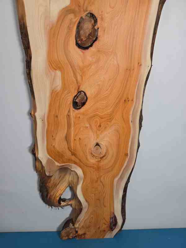 Bold Yew timber board with natural edges and prominent knots for woodworking.