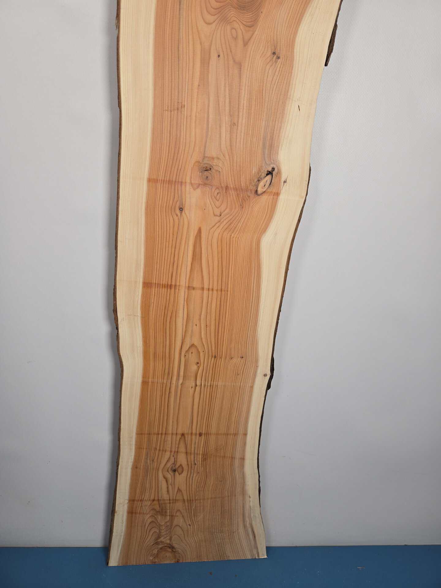 Narrow Yew timber board with natural edge and light pinkish wood grain.
