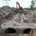 Heavy construction equipment installing large underground pipelines for site development.