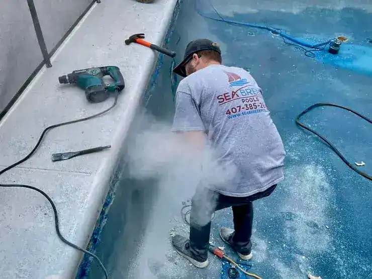 Sea breeze pools worker working on pool resurfacing cost in Orlando