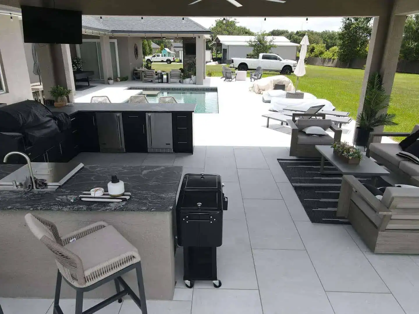 Outdoor kitchen with seating area next to a pool in Orlando, FL