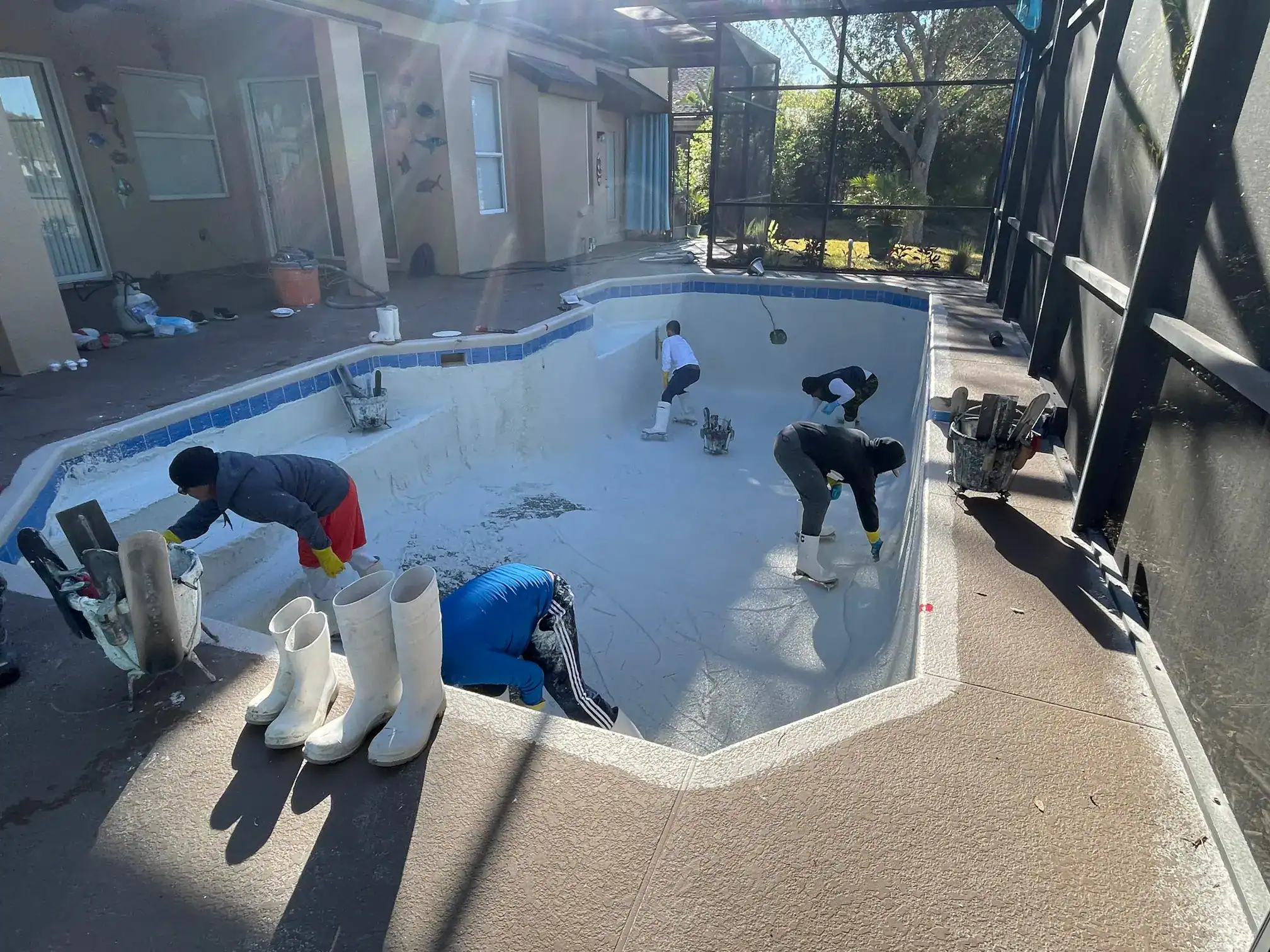 Five Sea Breeze Pool workers resurfacing an Orlando pool due to rough surfaces