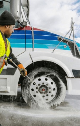 A See That Shine employee performs fleet vehicle detailing on a white tractor trailer