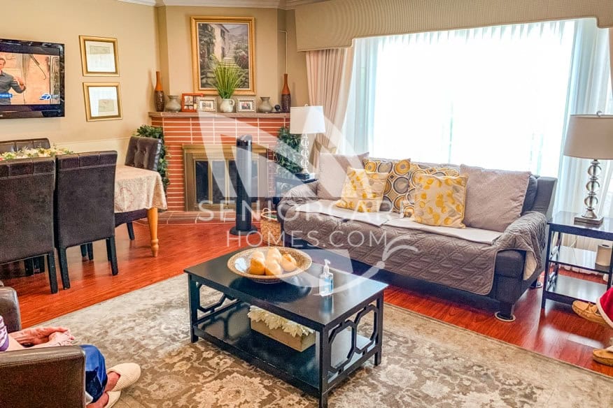 Living room area with a table and couches for a home-like feel at Damenik's Care Home 331 30th