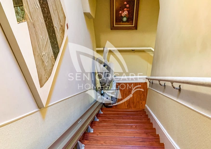View walking down the stairs with a senior assist elevator chair at Damenik's Care Home 331 30th