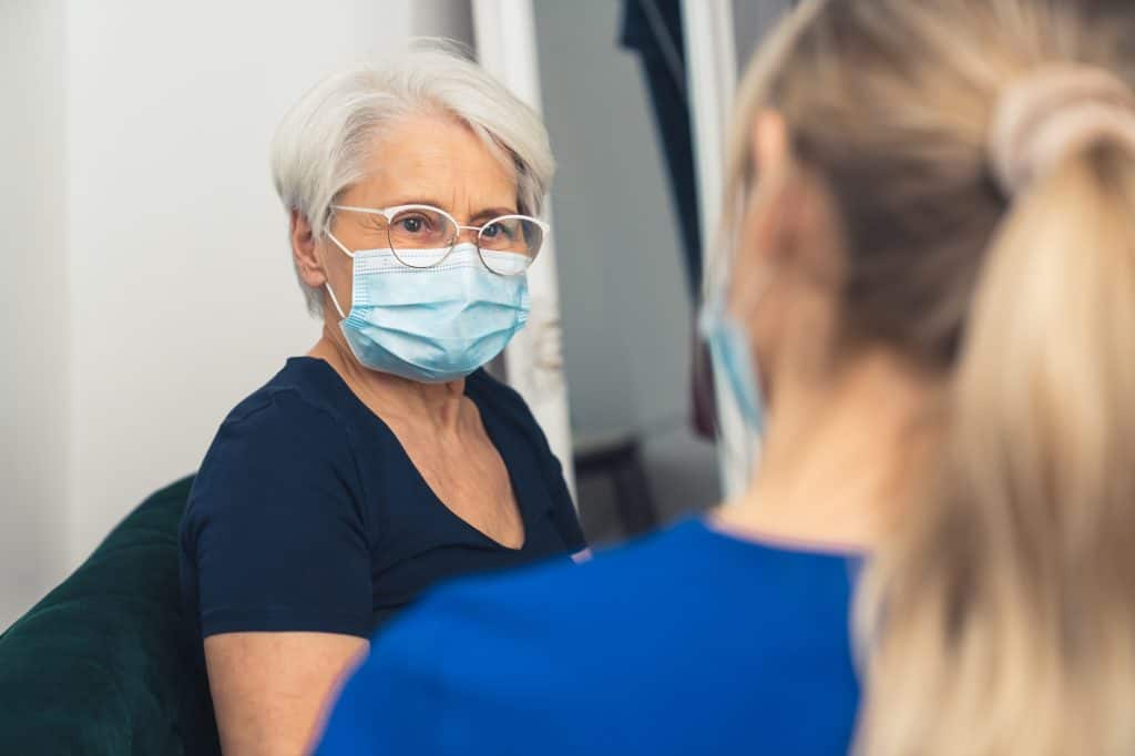 An older woman wearing a Covid mask with Joeline Garner Joel
