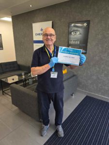 Servicemaster Manchester team member holding award in office.