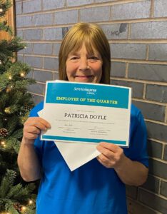 Happy woman holding Employee of the Quarter certificate at ServiceMaster Manchester.