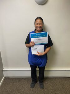 Happy employee holding Employee of the Quarter certificate at ServiceMaster Manchester.