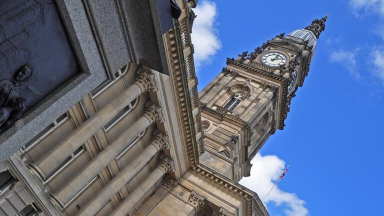 Town Hall clock tower against blue sky.