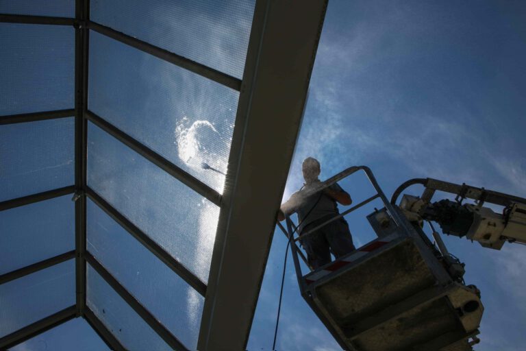 Professional high-level window cleaning using cherry picker equipment.