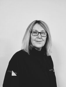 Female team member wearing glasses in black uniform at ServiceMaster Manchester.