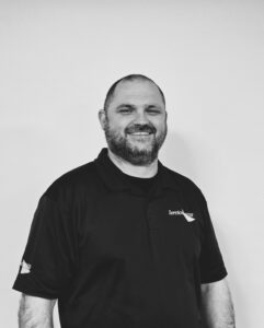 Friendly Servicemaster Manchester team member smiling in uniform.