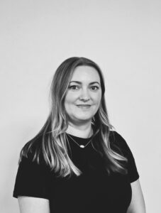 Female team member from ServiceMaster Manchester smiling in black and white.