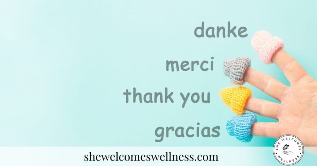 A hand with colorful knitted hearts on fingertips is against a light blue background. Words "danke," "merci," "thank you," and "gracias" appear, conveying gratitude.