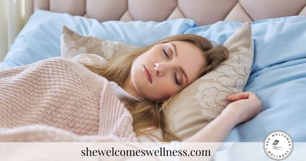 Young woman sleeping peacefully in bed with a beige knitted blanket and decorative pillows. The atmosphere is calm and restful.
