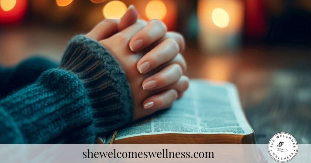 Hands in cozy knitted sleeves rest on an open book, with softly glowing candles in the background, creating a warm, peaceful atmosphere.