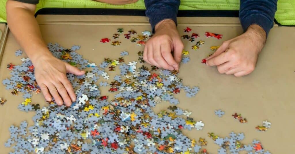 two people doing a jigsaw puzzle