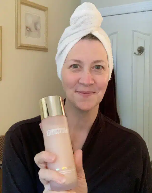 Tina holding Hydrating Essence, Step 2 of the skincare routine for mature skin