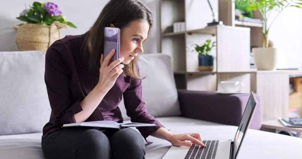Woman working on laptop and cellphone