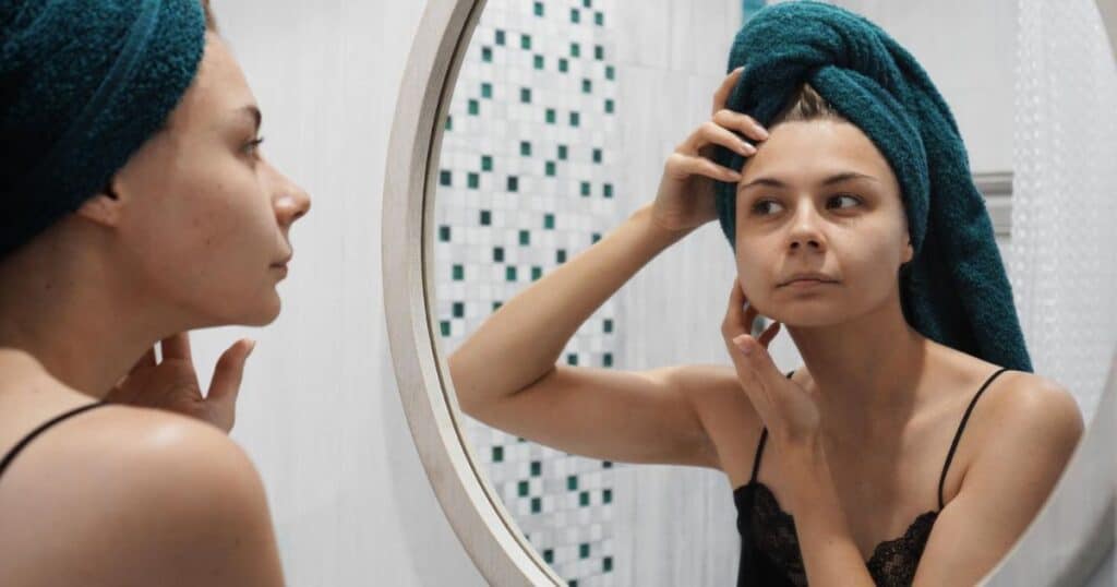 Woman making the skincare mistake of picking her face