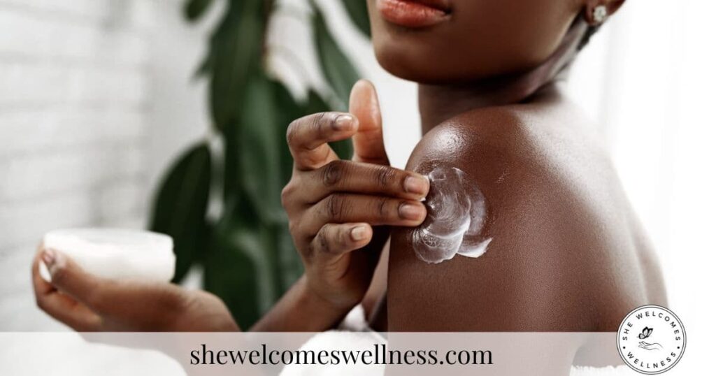 A close-up of a person applying lotion to their shoulder, conveying self-care. The background has a leafy plant.