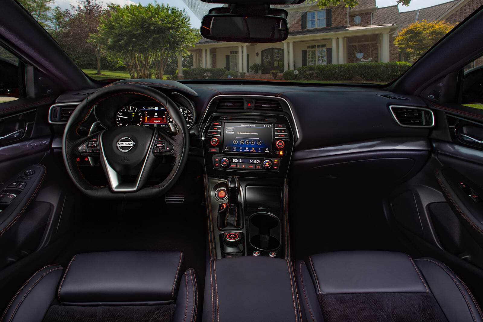 Interior dashboard and steering wheel of Nissan Maxima with custom accessories.