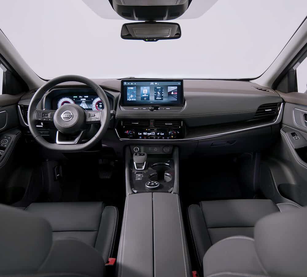 Interior dashboard and steering wheel of Nissan X-Trail with custom accessories.