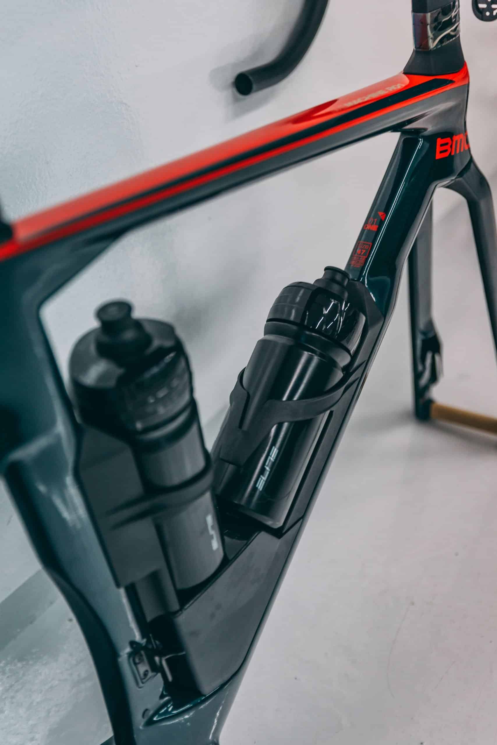 Bike frame with water bottles and shock absorber for road cycling protection.