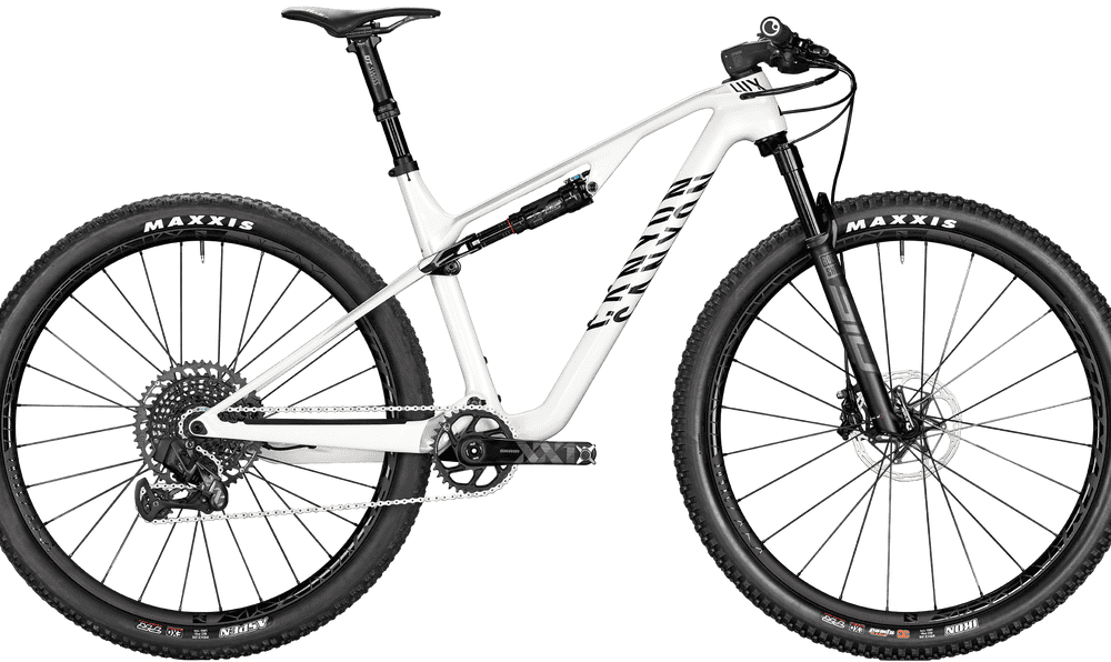 White mountain bike with suspension forks, wide tires, and disc brakes for off-road cycling.