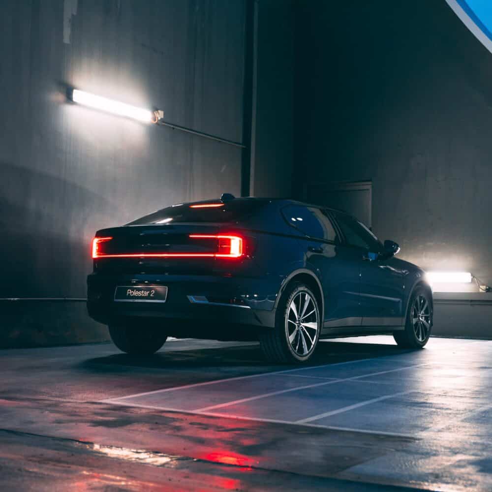 Polestar 2 electric vehicle parked in a modern indoor garage with ambient lighting.