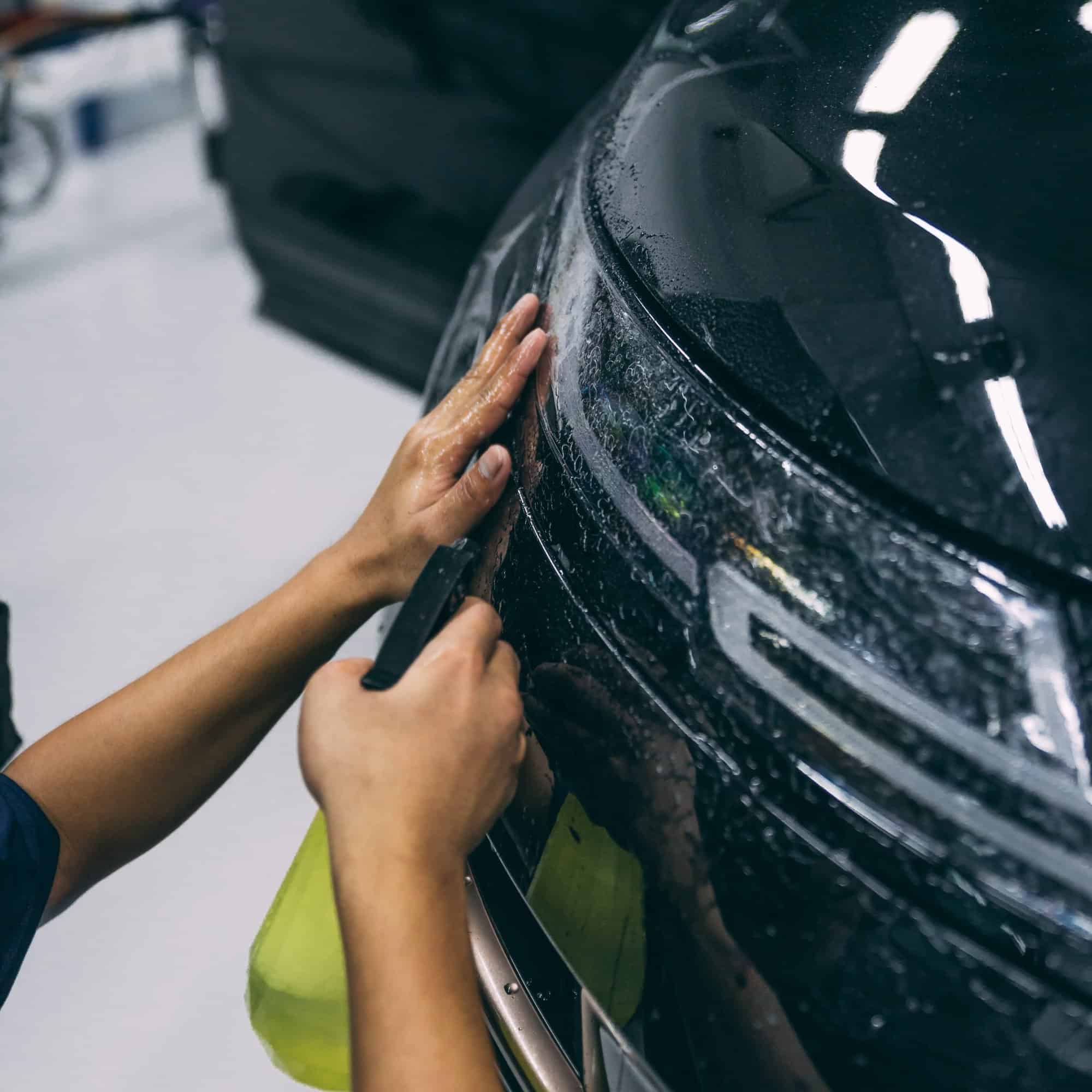 Applying stone chip protection film on car windshield and headlamp.