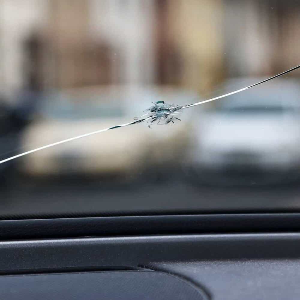 Car windshield with crack repair film for stone chip protection.