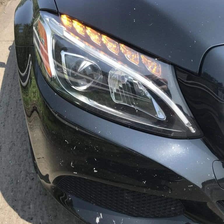 Car headlamp with protective film for stone chip prevention and windshield protection.