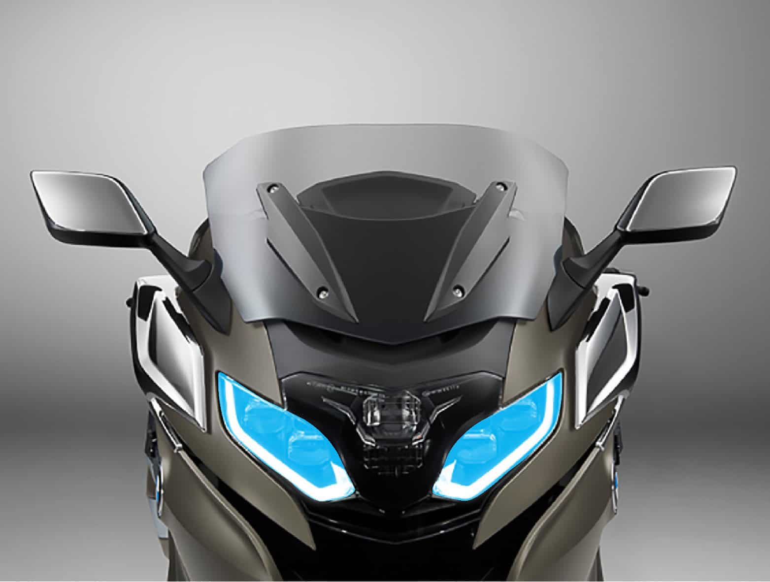 Motorcycle with aerodynamic windshield and bright LED headlights.