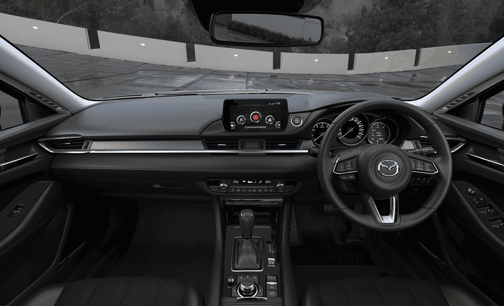 Interior dashboard and steering wheel of Mazda 6 with custom accessories.
